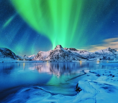 Aurora borealis über schneebedeckten Bergen