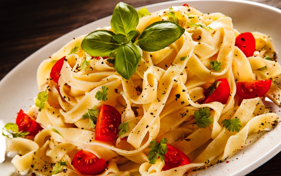 Nudeln mit Tomaten auf Holztisch