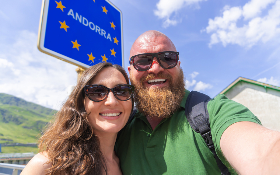 Reisende vor Andorra-Schild