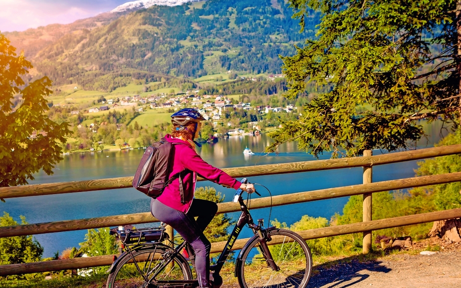 Frau mit E-Bike Radfahren neben einem schönen See-See und Fahrrad