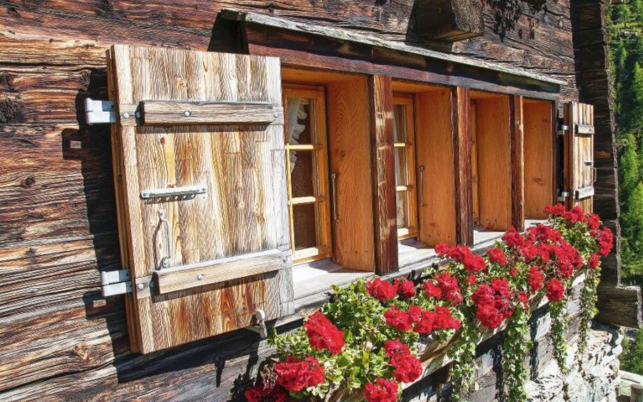 Typisches Fenster mit Blumen in den schweizer Bergen