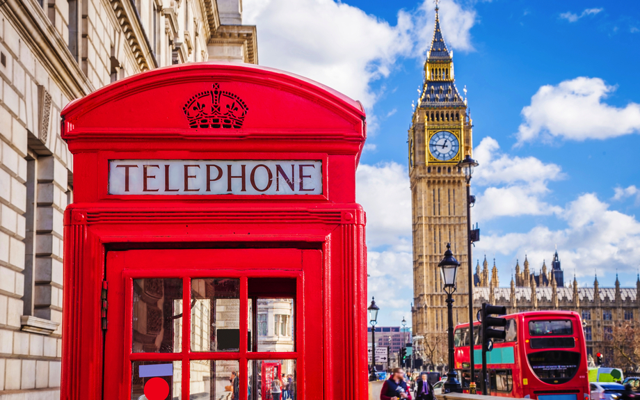 traditionelle rote britische Telefonzelle mit Big Ben und Doppeldeckerbus im Hintergrund in London
